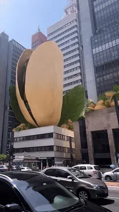 FOOH: pistache gigante dourado no topo de um prédio, com rua e carros ao fundo