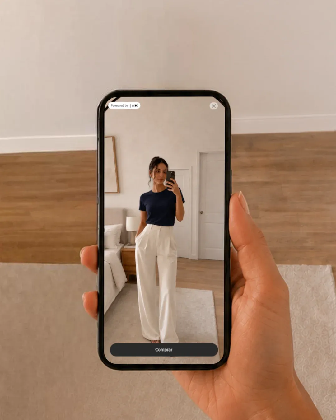 Provador virtual (mK Fashion): celular com app 'Powered by mK' mostrando selfie de mulher experimentando look, botão Comprar
